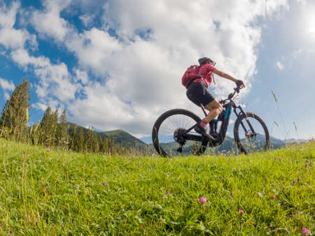 active senior woman riding her electric mountain bike in the Allgau Alps near city of Immenstadt, AlgÃ¤u, Bavaria, Germanyの写真素材