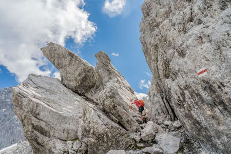 senior woman hiking in the wild terrain below the Drosa Tor in the mountains of Montafon valley, Vorarlberg, Austriaの写真素材