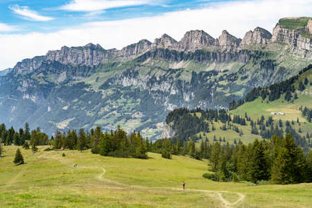 nice active woman riding her electric mountain bike below the seven summits of Churfirsten in Canton St. Gallen, Switzerlandの写真素材