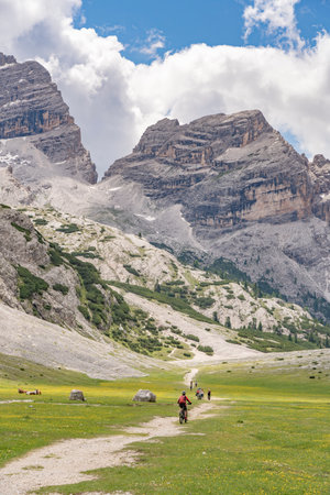 nice active senior woman riding her electric mountain bike in the Fanes high Valley, part of Fanes-Sennes-Braies nature park in the Alta Badia Dolomites, South Tirol and Trentino, Italyの写真素材