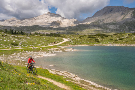 nice active senior woman riding her electric mountain bike in the Fanes high Valley, part of Fanes-Sennes-Braies nature park in the Alta Badia Dolomites, South Tirol and Trentino, Italyの写真素材