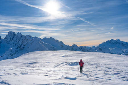 active senior woman snowshoeing from Prato Piazzo up to the Monte Specie in the three peaks Dolomites area near village of Innichen, South Tyrol, Italyの写真素材