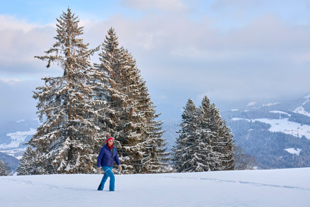 Young woman walking on snow in the mountains. Beautiful winter landscape.の写真素材