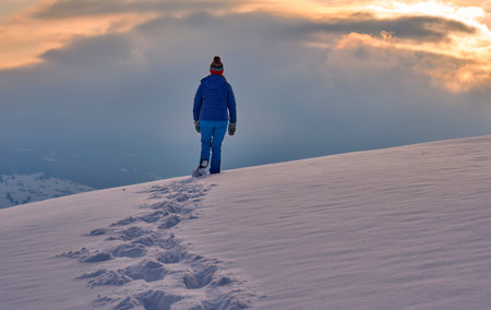 Hiker on the top of the mountain at sunset in winter.の写真素材