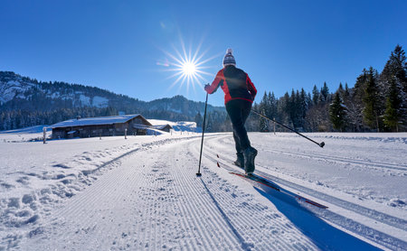 beautiful active senior woman cross-country skiing in fresh fallen powder snow in the Allgau alps near Balderschwang, Bavaria, Germanyの写真素材