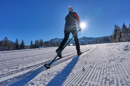 beautiful active senior woman cross-country skiing in fresh fallen powder snow in the Allgau alps near Balderschwang, Bavaria, Germanyの写真素材