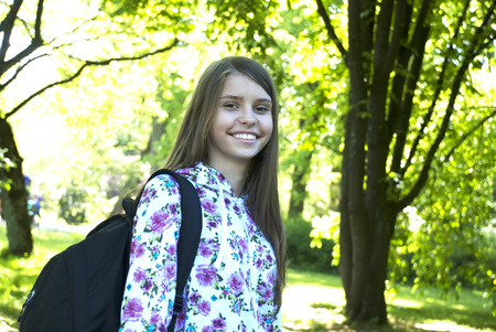 Portrait of happy and smiling teenage girl with school bag