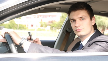 Portrait of an handsome young businessman sitting in his carの写真素材