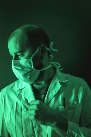 A doctor working sadly on the coronavirus pandemic, Covid-19の写真素材