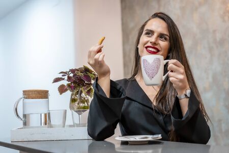 A young caucasian brunette in a cafe having coffee, street styleの写真素材