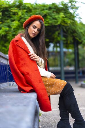 Street style, a young caucasian brunette sitting in a park in the cityの写真素材