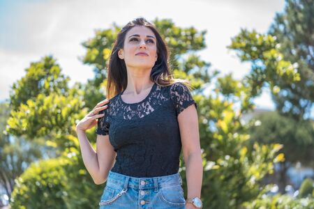 Street style, young brunette in a black t-shirt and denim shortsの写真素材