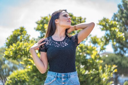 Lifestyle, a pretty young brunette in a black T-shirt and ripped denim shortsの写真素材