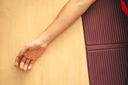 Yoga at home, detail of a young woman's hand lying on the mat. In the coronavirus quarantineの写真素材