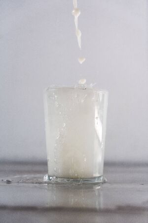 Throwing milk into a glass on a white background. Drink macro photographyの写真素材