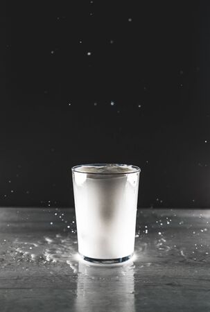 A glass of milk on a black background. Drink macro photographyの写真素材