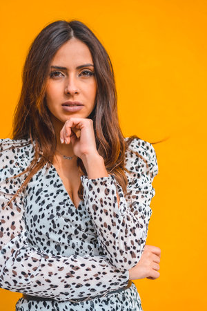 Lifestyle, portrait a young brunette woman in a black and white dress on a yellow background