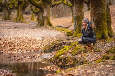 Caucasian blonde in a beautiful forest riverの写真素材