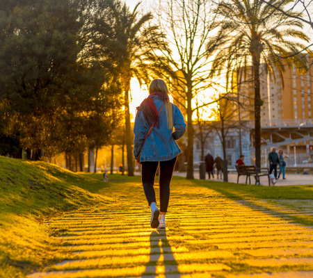 Lifestyle, a young woman walking in a sunset