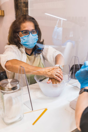 Beauty Salon, reopening of the business after the coronavirus pandemic. A client cleaning her hands. Covid-19