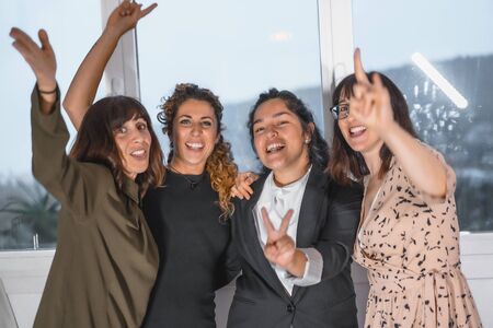 Session young entrepreneurs in the office, 3 young Caucasian women and a young Latina celebrating the end of the projectの写真素材