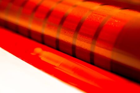 Traditional offset press. Printing in ink with CMYK, cyan, magenta, yellow and black. Graphic arts, offset printing. Detail of a printing roller in a four-body magenta offset machineの写真素材