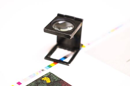 Traditional offset press. Printing in ink with CMYK, cyan, magenta, yellow and black. Graphic arts, offset printing. Adjusting tool for sheet control stripsの写真素材