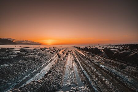 The incredible Flysch, a beautiful sunset in Sakoneta, is a beach in Deba. It is the western end of the Geopark of the Basque Coast, Guipuzkoa, Basque Country. The day ends with the sunsetの写真素材