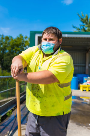 Worker in a recycling factory or clean point and garbage with a face mask and with security...