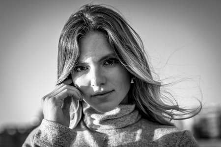 Lifestyle, a blonde on the beach at sunset with the sun in the background. Black and white summer portraitの写真素材