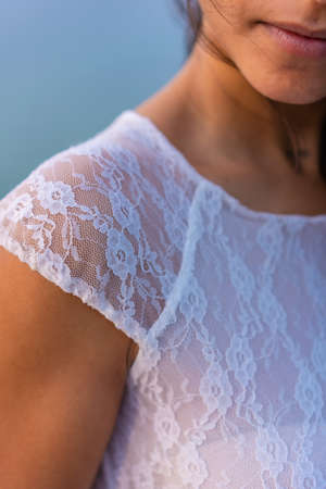 Lifestyle, detail of the seam texture of the bride's beautiful white dress. Caucasian brunette on her wedding dayの写真素材