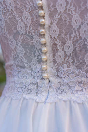 Lifestyle, detail of the seam texture of the bride's beautiful white dress. Caucasian brunette on her wedding dayの写真素材