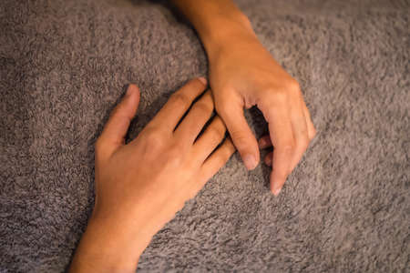Hands of a relaxed young woman at the massage of a physiotherapist on the table. Physio, osteopathyの写真素材