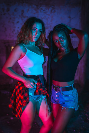 Urban photography, a young Caucasian and another black girl in a pose, with a tight white and black...