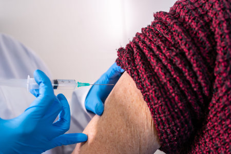 Female doctor injecting the coronavirus vaccine to an elderly lady. Antibodies, immunize population....