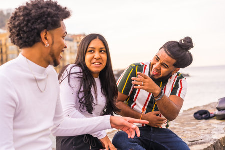 Lifestyle, three black friends smiling a lot in the city with the sunset in the background, slimming and millennial in the city. Afro hair boy, brunette boy with long hair and brunette girlの写真素材