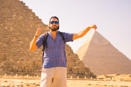 Portrait a young tourist at the pyramid of Cheops the largest pyramid. The pyramids of Giza the oldest funerary monument in the world. In the city of Cairo, Egyptの写真素材