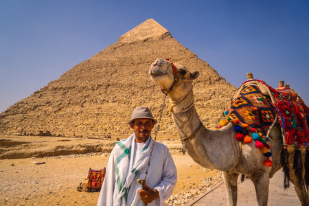 Cairo, Egypt; October 2020: A local vendor with his camel at the Pyramid of Kefren. The Pyramids of Giza the oldest funerary monument in the worldのeditorial素材
