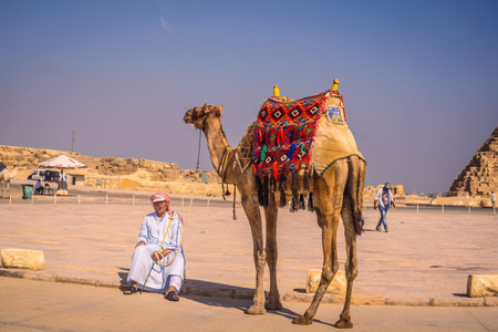 A man and a camel at the pyramids of Giza the oldest Funerary monument in the world. In the city of Cairo, Egyptのeditorial素材