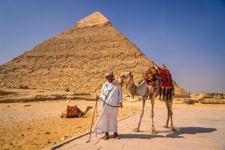 Cairo, Egypt; October 2020: A local vendor with his camel at the Pyramid of Kefren. The Pyramids of Giza the oldest funerary monument in the worldのeditorial素材