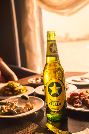 Cairo, Egypt; October 2020: A traditional dinner of the country accompanied by a local beer at the sunset of the Nileのeditorial素材