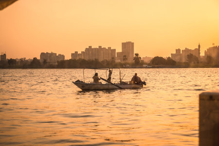 A family of local fishermen at sunset on the Nile river with the city of Cairo in the background....