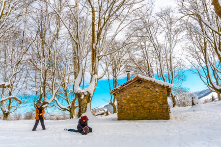 Hikers next to the beautiful refuge among giant trees in the Oianleku natural park in the town of...