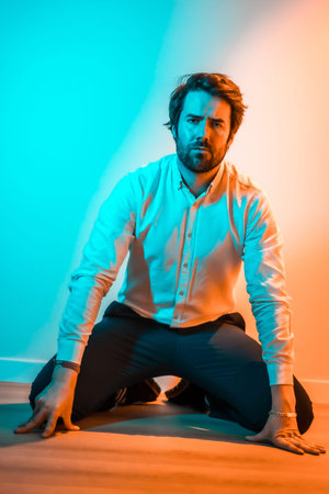Studio lifestyle, sweet look of a Caucasian man in a white shirt, illuminated with an orange and...