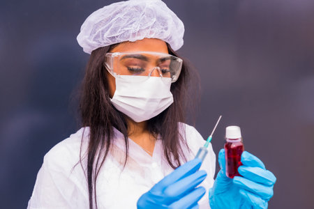 African-American doctor with the  vaccine in her hands, immunizes the population, people at risk, antibodies, new normalの写真素材