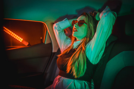 Photograph with neon lights in the back of a car of a young blond Caucasian woman with heart glasses