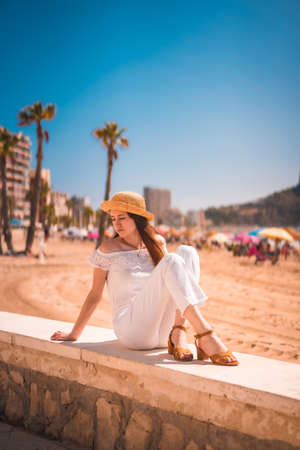 Lifestyle of a young red-haired Caucasian girl dressed in white and with a straw hat on the beaches of Calpe, Valencia. Spainの写真素材