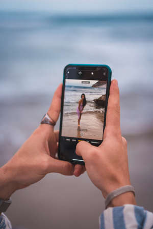 Photo of a brunette Caucasian with a pink fabric dress, on the beach in the sea enjoying the holidaysの写真素材