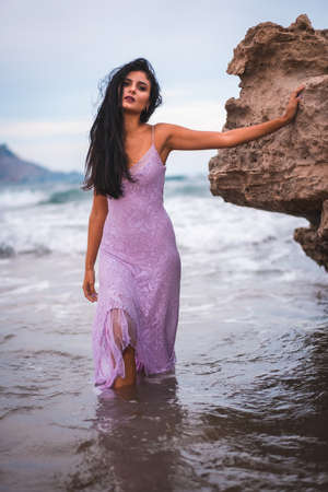 Caucasian brunette with a pink cloth dress, on the beach in the sea in Cabo de Gata, Nijar. Andalucia in Spainの写真素材