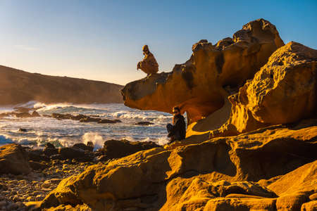Two sisters at sunset in the stone cove on the Jaizkibel mountain in the town of Pasajes near San Sebastian. Basque Countryの写真素材